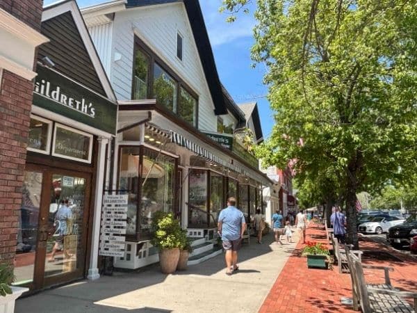 downtown street of southmpton NY, shops fronts and cute sidewalk lined by trees and planters